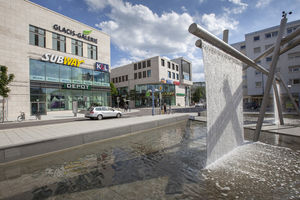 Im Vordergrund der Brunnen am Neu-Ulmer Heiner-Metzger-Platz, im Hintergrund das Einkaufzentrum Glacis-Galerie
