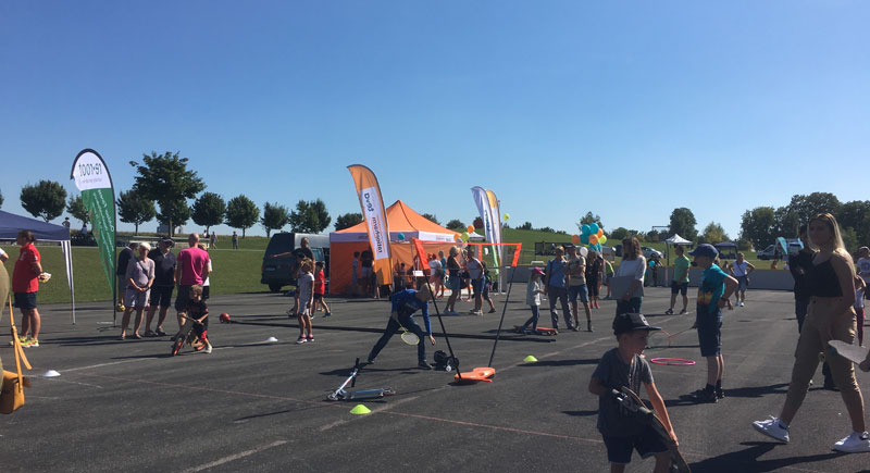 Kinder und Erwachsene an verschiedenen Spiel- und Sportstationen auf dem Hartplatz im Sport- und Freizeitpark Wiley
