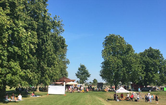 Blick auf einen Teil des Sport- und Freizeitpark Wiley mit dem Wiley-Kiosk, Spielstationen und Besuchern