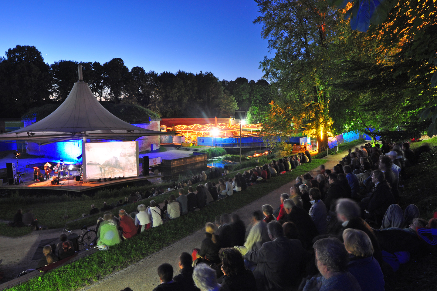 Open-Air-Filmvorführung auf einer großen Leindwand im Neu-Ulmer Glacis-Park mit vollbesetzten Zuschauerrängen