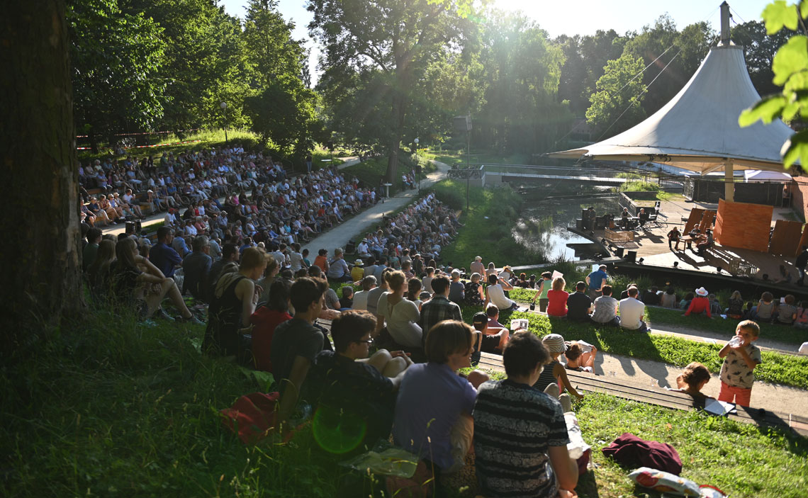 Voll besetzte Zuschauerränge vor der Veranstaltunsbühne im Neu-Ulmer Glacis-Park