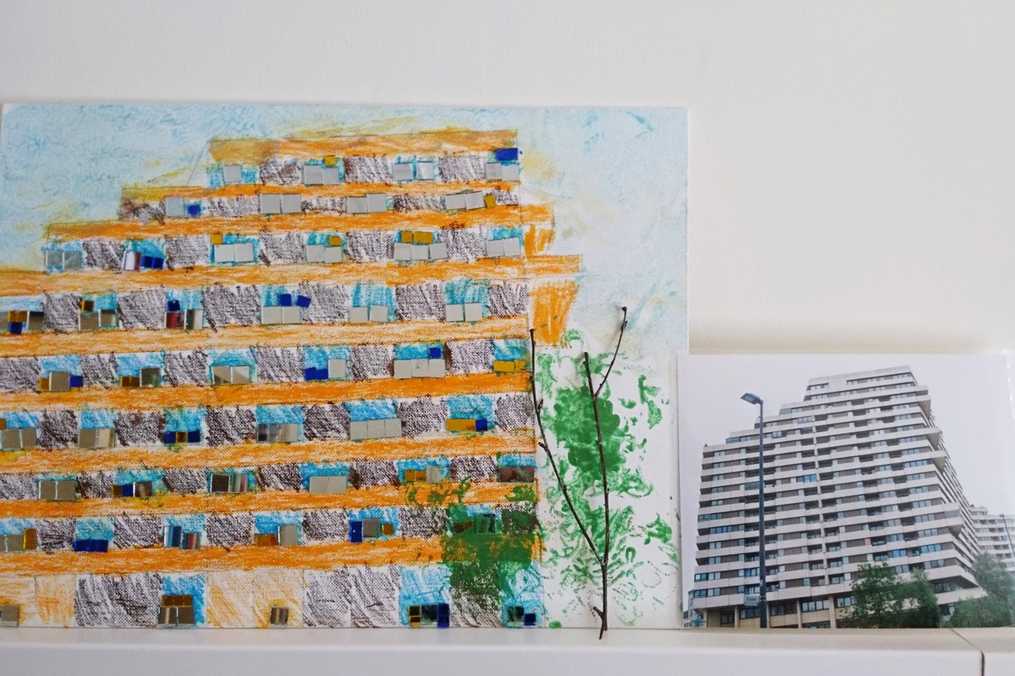 Das Neu-Ulmer Hochhaus "Donaucenter" auf einem Foto und auf daneben auf Papier gemalt
