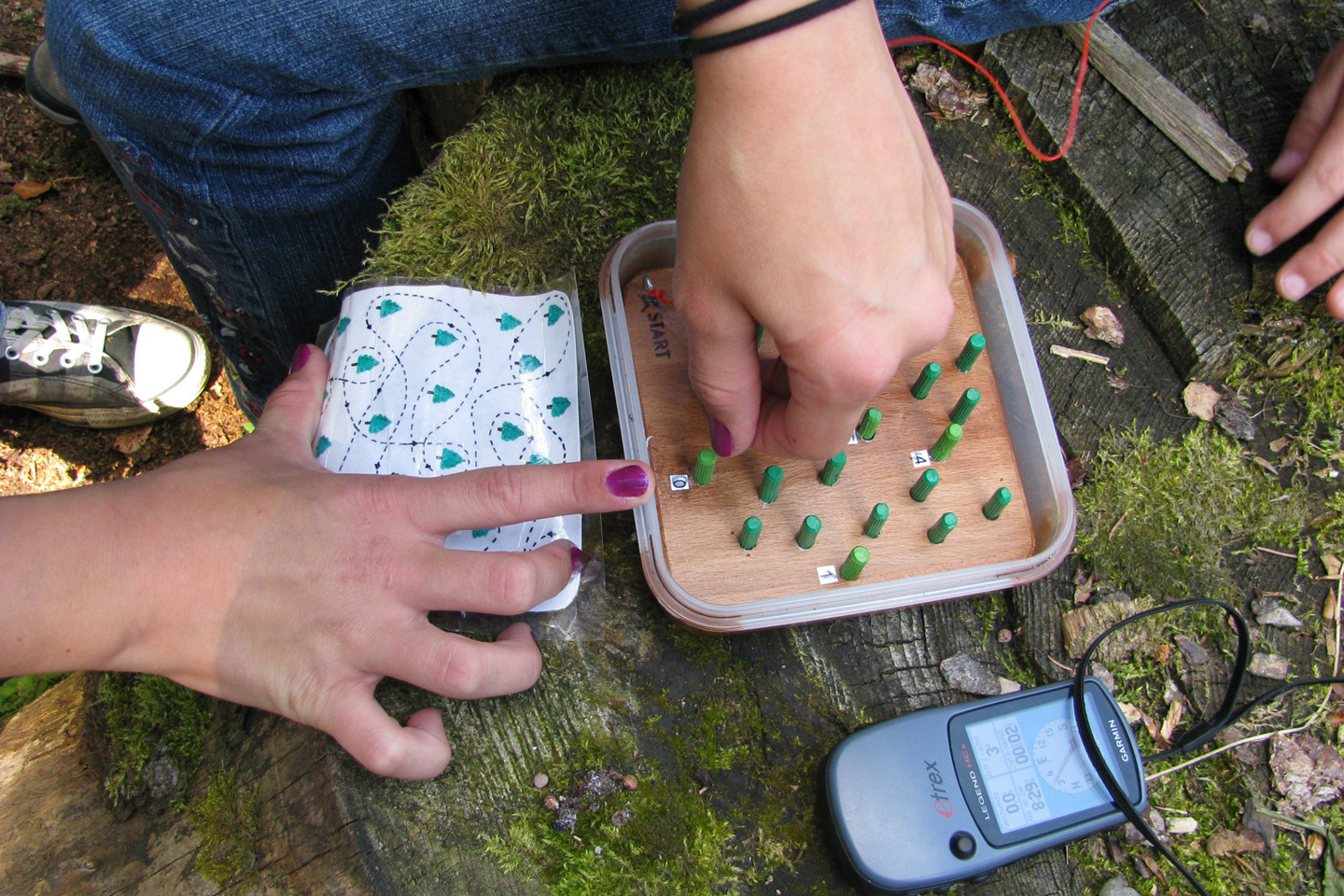 Foto von einem Rätsel und einem Kompass beim Geocaching