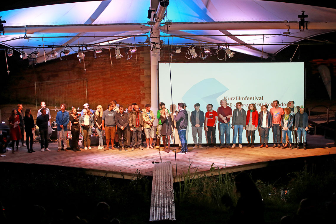 Alle Filmemacher der eingereichten Kurzfilme, die Moderatoren und die Band gemeinsam auf der Veranstaltungsbühne im Glacis-Park