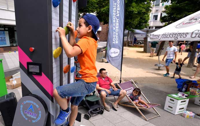 Ein Junge klettert an einer Kletterwand hinauf
